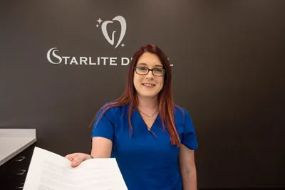 front desk coordinator at Starlite Dental passing out insurance paperwork