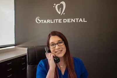 front desk coordinator at Starlite Dental talking on the phone with a patient