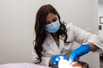 Dr. Jaiswal of Starlite Dental in McKinney, TX taking a look at a patient's teeth