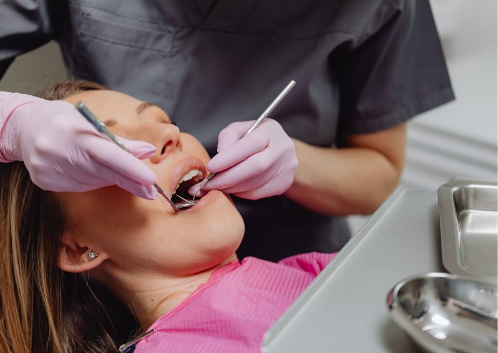 Dentist performing a professional dental cleaning to remove plaque and tartar as part of gingivitis treatment.