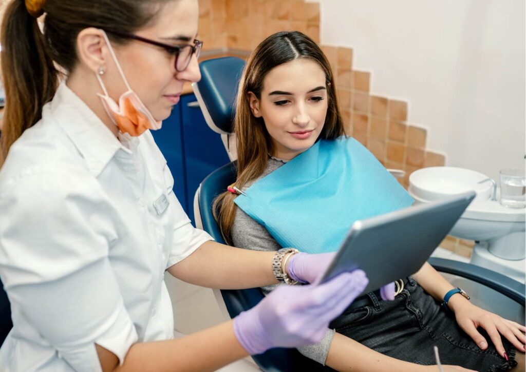 Dentist explaining treatment options to a patient after evaluating whether a cavity can heal on its own or needs a filling.