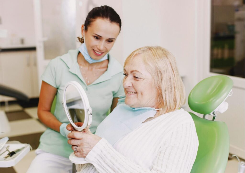 Older adult reviewing her smile with a dentist during a consultation to determine whether it is too late to get dental implants.