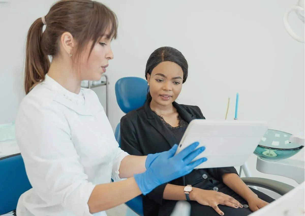 Dentist discussing alveoloplasty treatment and jawbone reshaping with a patient before a dental procedure.