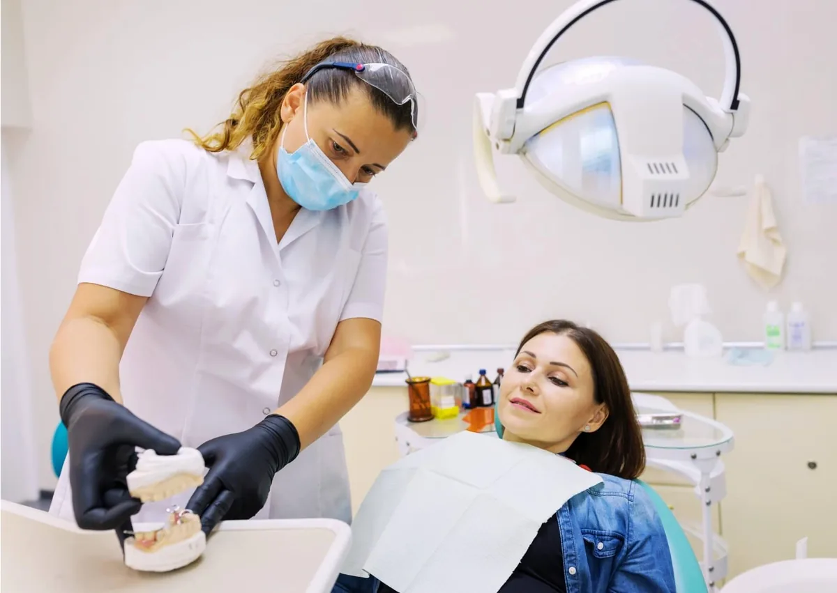 Dentist discussing dental implant treatment and sedation options with a patient before the procedure.