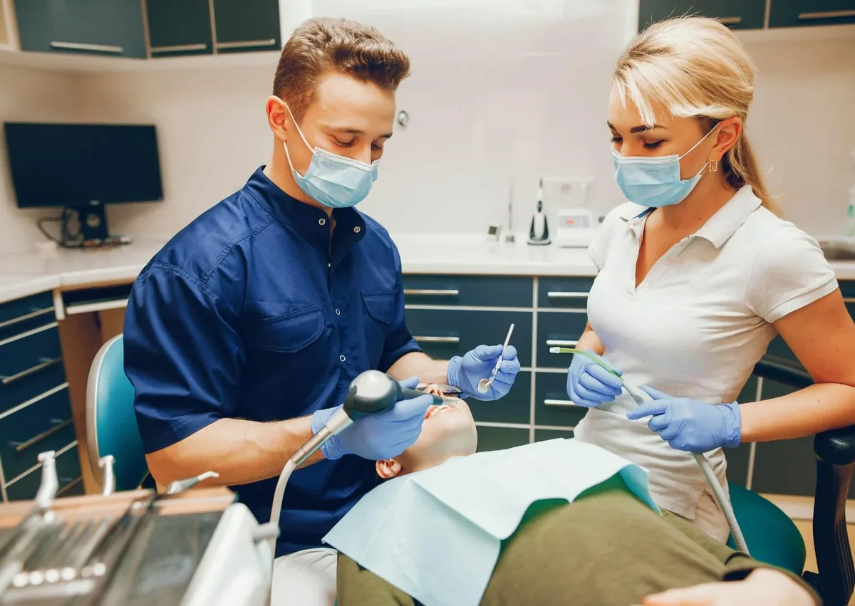 Dentist treating a patient while discussing dental crown types and factors that influence crown cost.