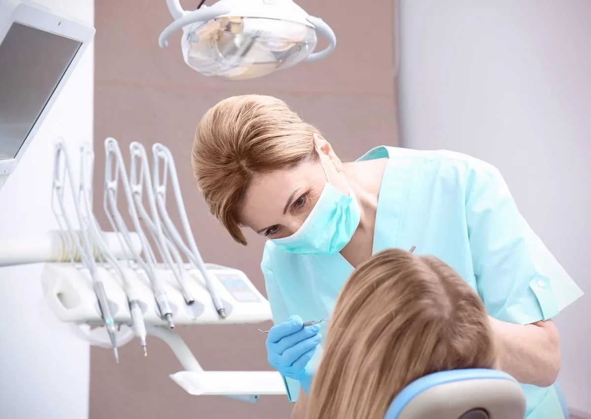 Dentist examining a patient after wisdom teeth removal before returning to solid foods.