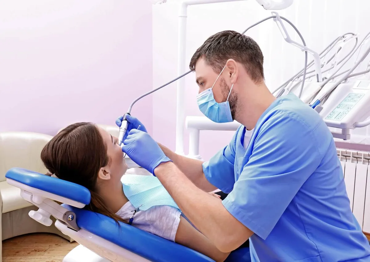 Dentist treating a relaxed patient during a procedure with nitrous oxide sedation.